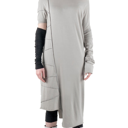 LOCO ONE REVOLUTION COLLECTION. DRESS GRIGIO. This is a longer version of our LOCO ONE TOP LATERAL with a wider neck line, the left sleeve is loose and extra long, the right side has a wing short sleeve. features the upside down seams all the way down the right side with raw asymmetric hems. This dress is loose fit.