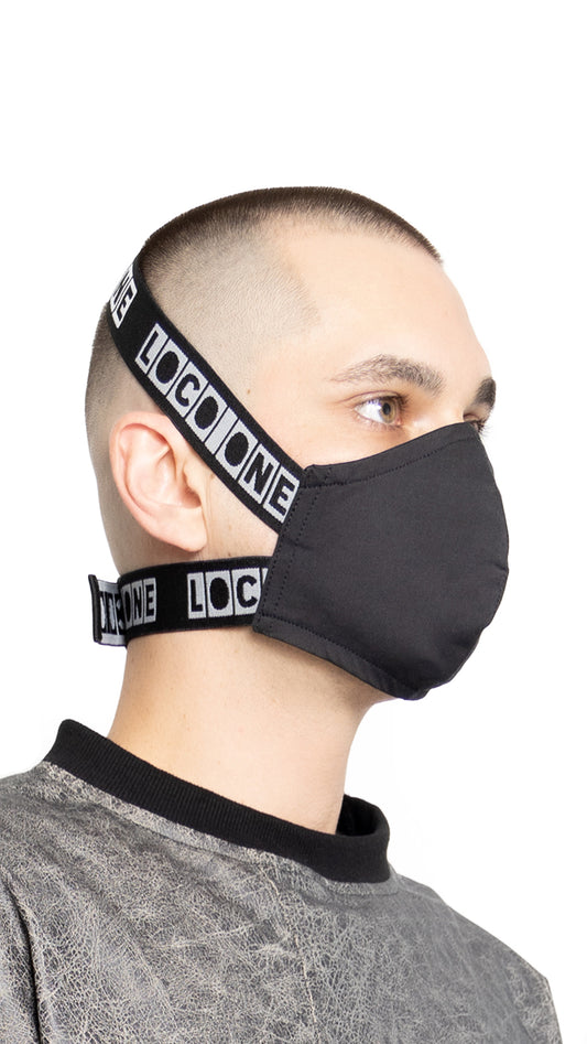 LOCO ONE REBOOT COLLECTION.  MASKA CHANGE BLCK.  The Avant-garde LOCO ONE MASKA CHANGE in blck is made of two layers of stretchy, soft COTTON. Adjustable woven straps on the neck with a plastic buckle for a better fit. You can wash it with soap and water in the comfort of your home every day to keep it nice and clean. The CDC recommends wearing face coverings in public places.