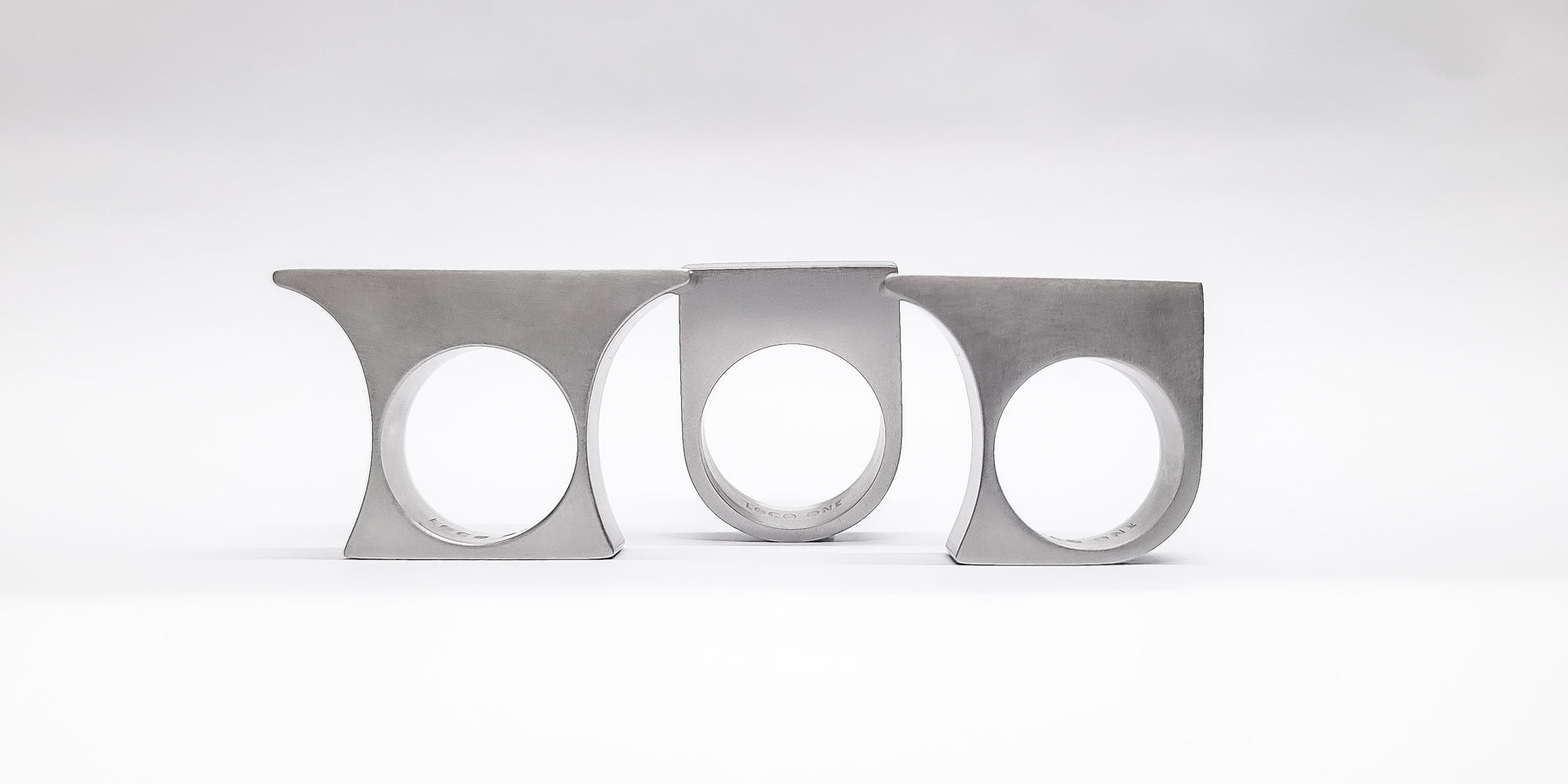 "Architecture worn not built". Three rings. One continuous structure. MONOLITH transforms the hand into architecture, each piece aligned in form, proportion, and intent. Raw, minimal, and precise.