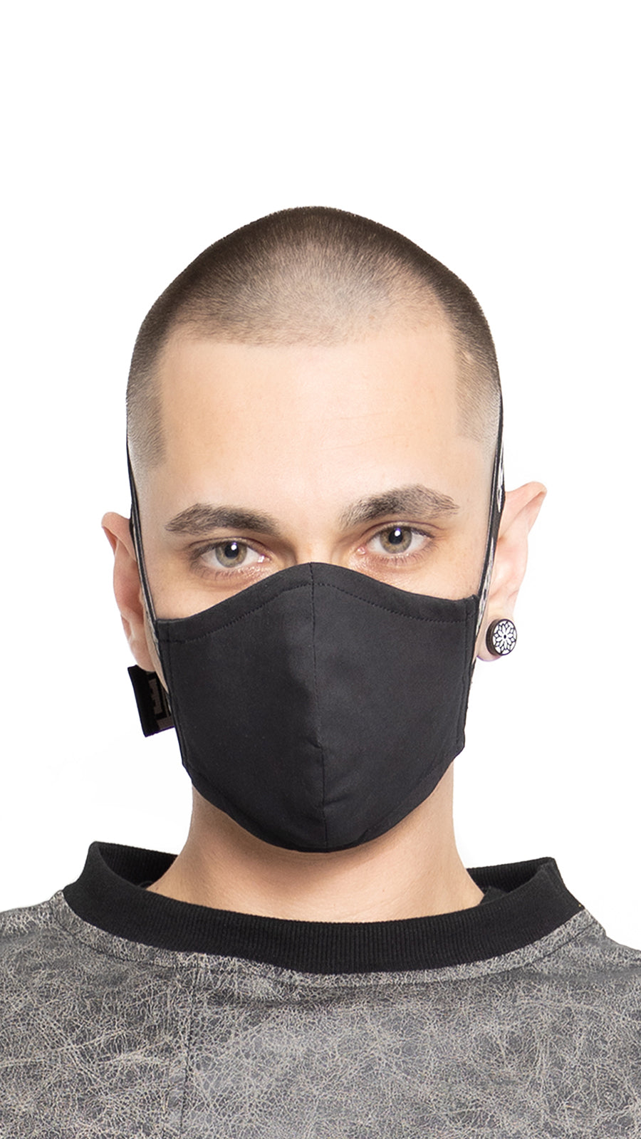 LOCO ONE REBOOT COLLECTION.  MASKA CHANGE BLCK.  The Avant-garde LOCO ONE MASKA CHANGE in blck is made of two layers of stretchy, soft COTTON. Adjustable woven straps on the neck with a plastic buckle for a better fit. You can wash it with soap and water in the comfort of your home every day to keep it nice and clean. The CDC recommends wearing face coverings in public places.