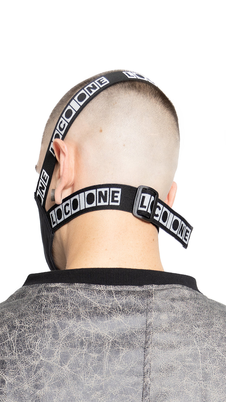 LOCO ONE REBOOT COLLECTION.  MASKA CHANGE BLCK.  The Avant-garde LOCO ONE MASKA CHANGE in blck is made of two layers of stretchy, soft COTTON. Adjustable woven straps on the neck with a plastic buckle for a better fit. You can wash it with soap and water in the comfort of your home every day to keep it nice and clean. The CDC recommends wearing face coverings in public places.